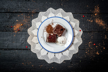 Chocolate cake with cream on retro wooden table