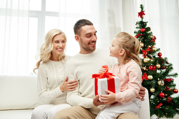 Obraz na płótnie Canvas happy family at home with christmas gift