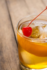 Old fashioned cocktail with cherry and orange peel