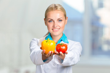 Portrait Of Happy Female Dietician With Fresh Vegetables And Diary