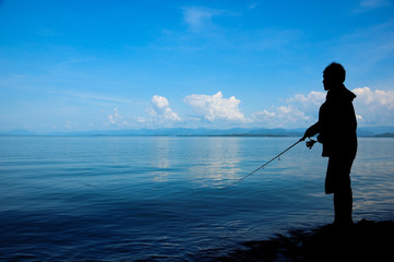 Silhouette fisherman on the shore