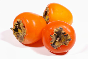 Three fetal persimmon on a white background.