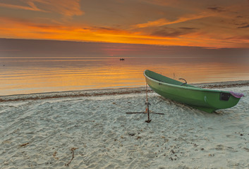 Anchored boat on sandy beach of the Baltic Sea