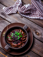 Mushrooms dumplings in a bowl on wooden table.