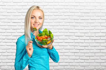 Beautiful girl eating fresh vegetable salad