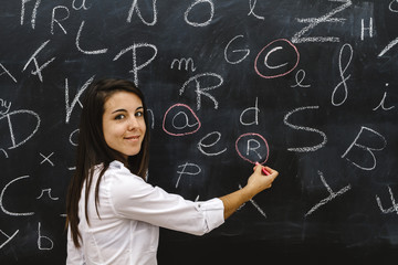 teacher in the classroom on blackboard background