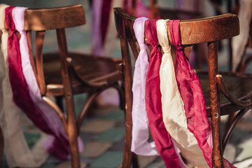 Fototapeta na wymiar Wedding chairs with ribbons ,wedding ceremony in outside