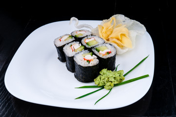 Decorated sushi served on a white plate. The meal is ready for eating.