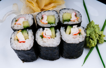Decorated sushi served on a white plate. The meal is ready for eating.
