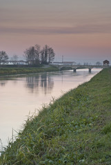 tramonto sulla pianura Vercellese ,con le nuvole riflesse sull'acqua del canale