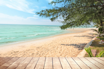 Fototapeta premium Wooden table with blurry tropical sea and resort background.