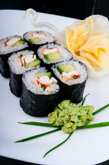 Decorated sushi served on a white plate. The meal is ready for eating.