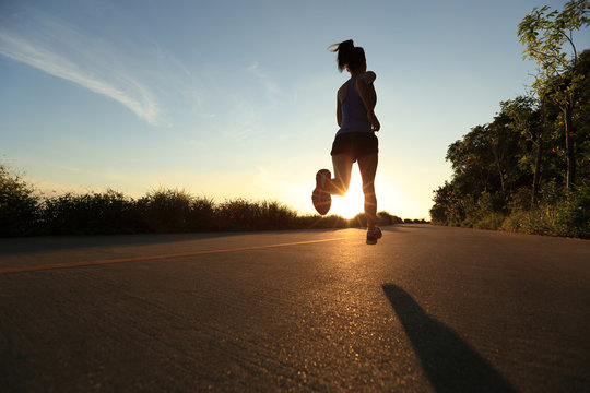 young fitness woman running on sunrise seaside trail
