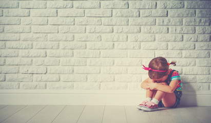 little child girl crying and sad about brick wall