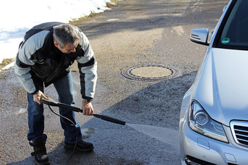 Autowäsche im Winter - Ein Mann wäscht im Winter sein Auto