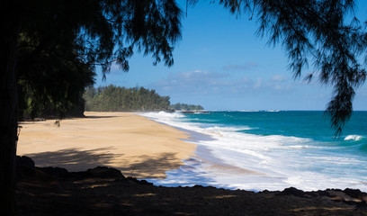 Powerful waves flow onto sand at Lumahai Beach, Kauai
