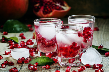 Fresh sparkling water with ice and pomegranate, selective focus