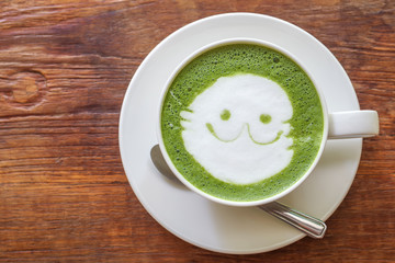 Top view of Japanese matcha green tea latte on wood background