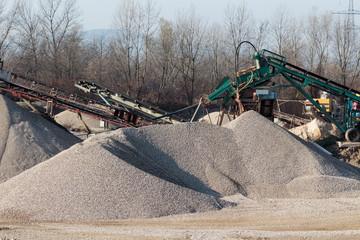 Large pile of gravel and old gravel digger conveyor belt