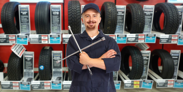 Car mechanic with tire wrench.