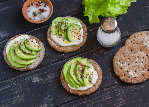 Healthy avocado sandwiches,  on a dark wooden surface. Healthy breakfast or snack