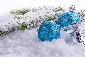 Christmas decorations - balls, bell and green branch on snow