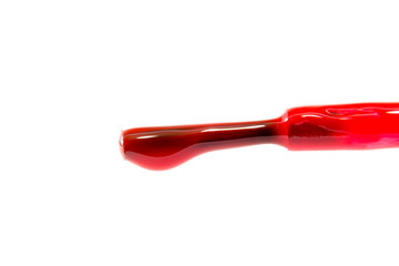 brush with a drop of red nail polish close-up macro isolated on a white background

