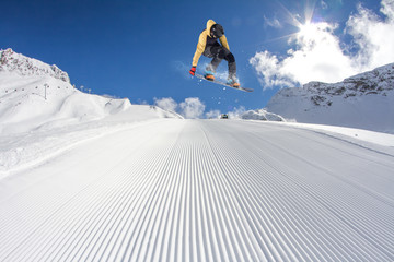 Flying snowboarder on mountains. Extreme sport.