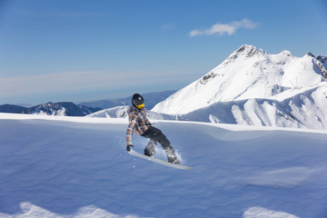 Flying snowboarder on mountains. Extreme sport.