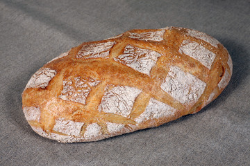 white bread lies on a grey linen tablecloth