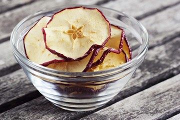 Sun dried apple chips on a rustic wooden table.Healthy snack.Selective focus 