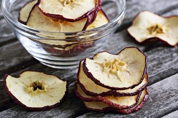 Sun dried apple chips on a rustic wooden table.Healthy snack.Selective focus 