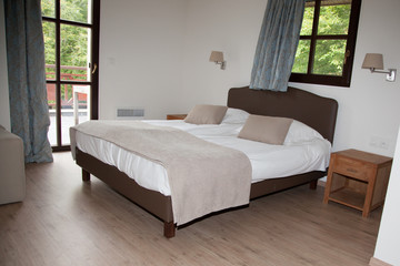 Double Bed In The Bedroom With Desk Lamp Near It