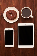 view from above of smartphone, tablet pc, donut and coffee