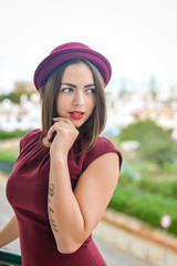 Attractive pensive brunette looking into distance standing on balcony alone