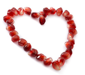Heart symbol made from pomegranate seeds isolated 