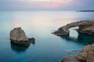 Stone arch and rocks in the sea after sunset near Ayia Napa. Cyprus