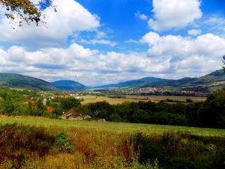 Meadow, forests, village and sky