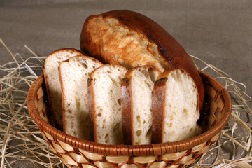 sliced white bread is in a straw basket on the tablecloth gray l
