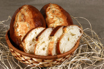 sliced white bread is in a straw basket on the tablecloth gray l