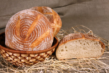white bread lay in a straw basket on gray linen tablecloth
