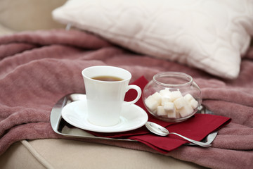 Cup of tea on sofa in living room