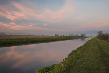 tramonto sulla pianura Vercellese ,con le nuvole riflesse sull'acqua del canale