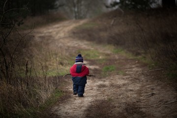 Naklejka premium Child walking in countryside at autumnal bad weather