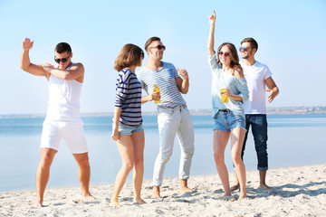 Obraz premium Young people with beer on the riverside