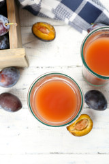 Plum Juice in glasses with fresh fruits
