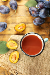 Plum Juice in mug with fresh fruits