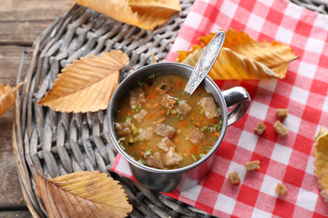 Mug of soup on wicker mat closeup