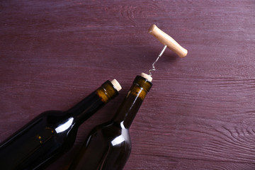 Two bottle wine and corkscrew on purple wooden background