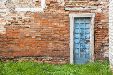 Fototapeta na wymiar Blue door on red brick wall